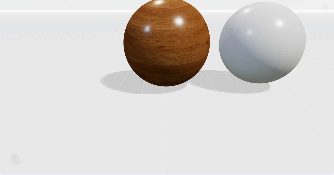 A wood and a satin-white sphere on a soft studio grid floor